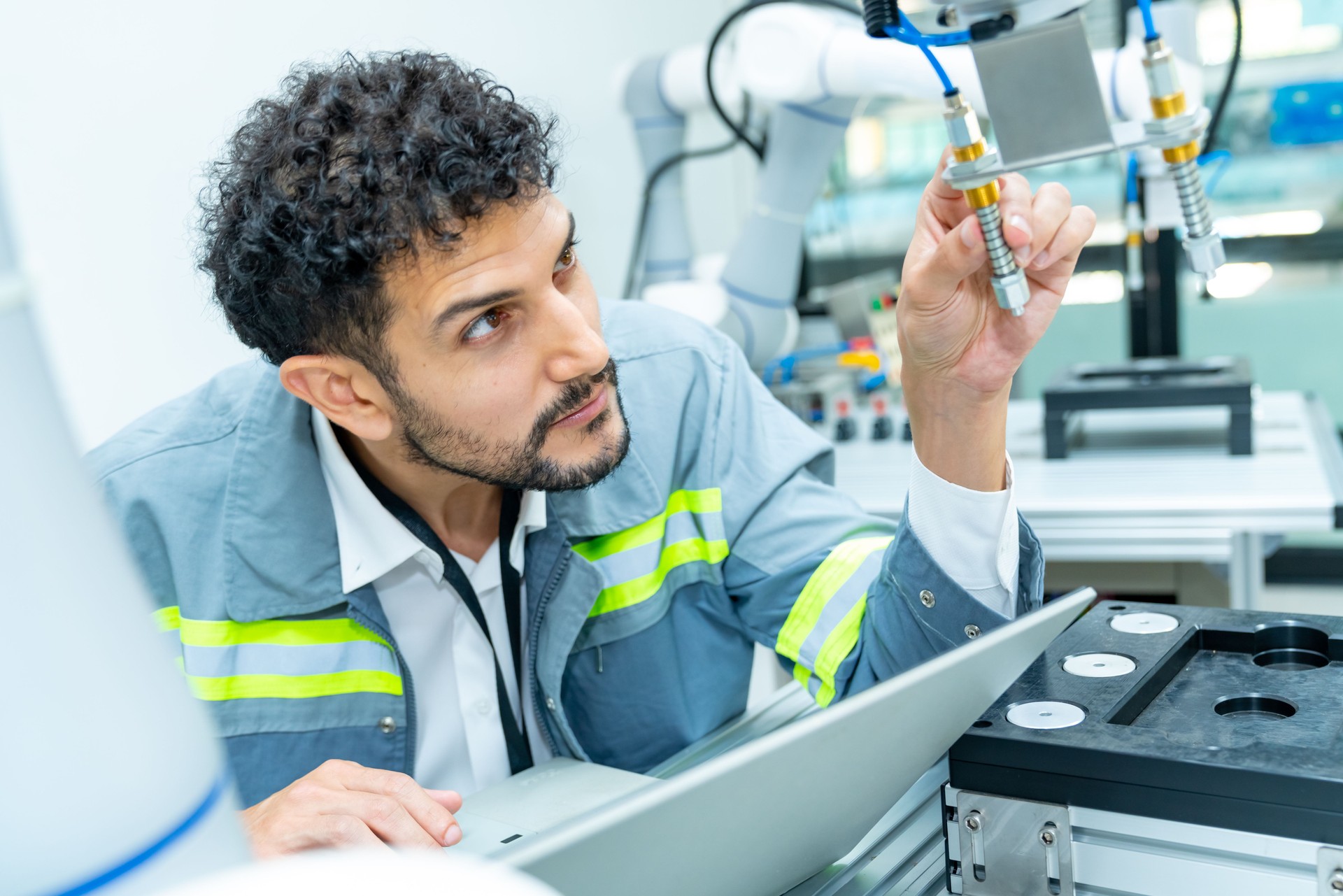 Male engineer working with robotic machine in factory.